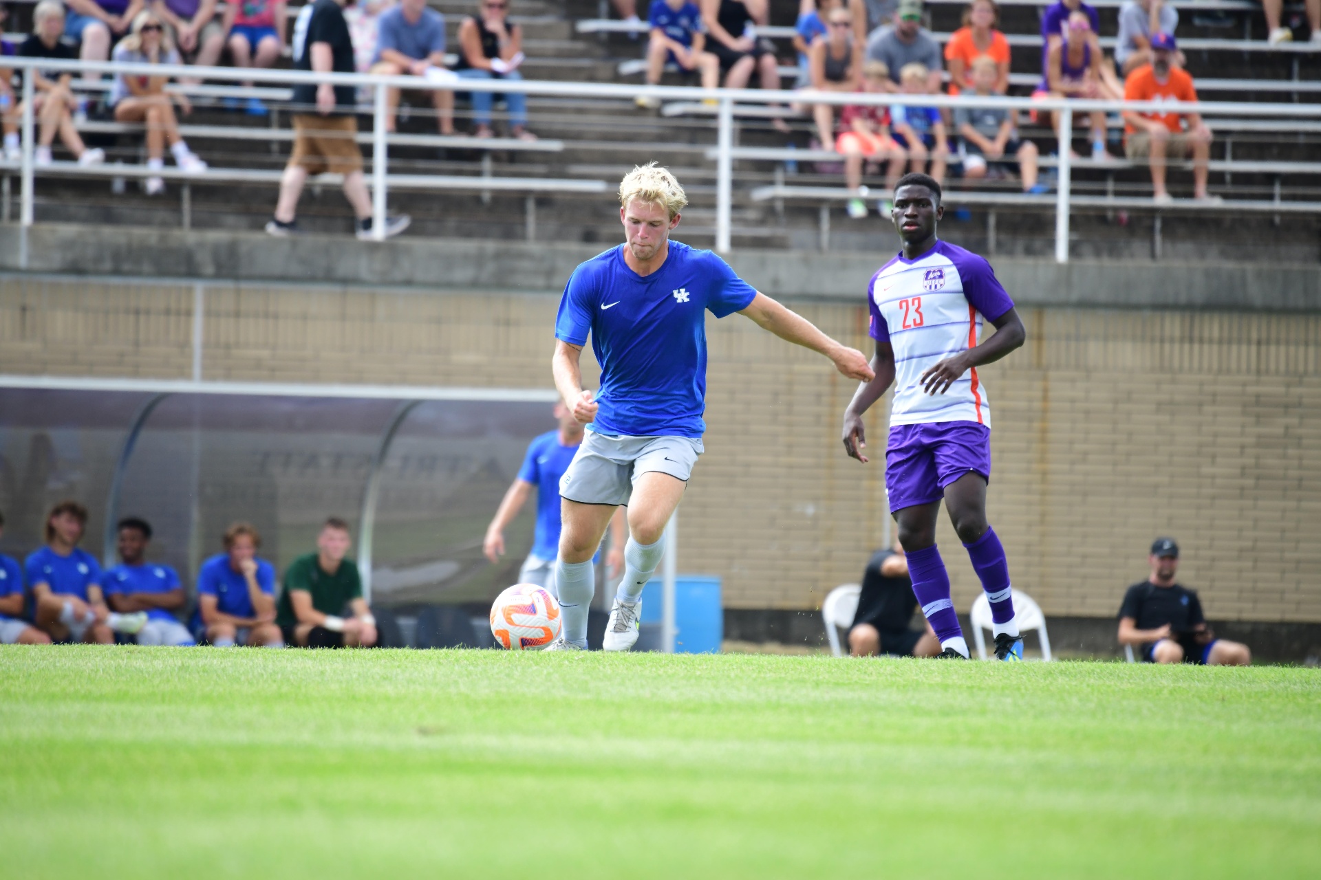 Cooper Kieran dribbling past a defender during a college soccer match